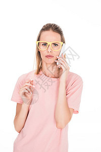 身戴纸板眼镜和用智能手机说话的年轻女子图片