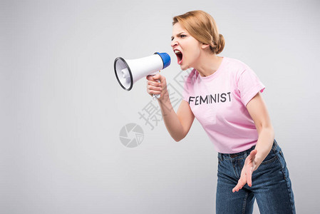 穿着粉红色女权运动者T恤的妇女对着手机大喊叫图片