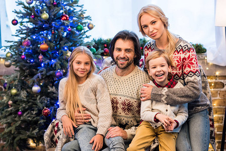 快乐的家庭美丽的毛衣拥抱和笑着的相机图片