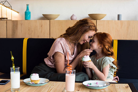快乐的母亲和女儿在咖啡馆吃蛋糕图片