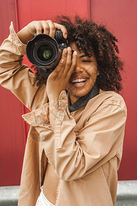 在街上使用数码相机的年轻非洲女快图片