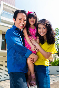 亚裔中庭父母和子女在现代家门前自豪图片