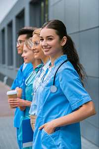 站在医科大学附近一排的教师和幸福多文化学生的侧图片