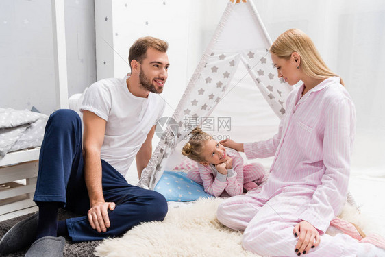 小女儿和父母在一起坐在地板上的手工艺的茶叶子上图片