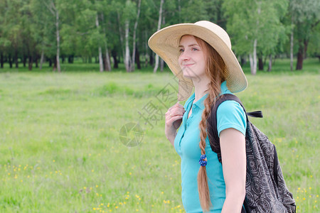 背着包和帽子的女孩站在夏图片