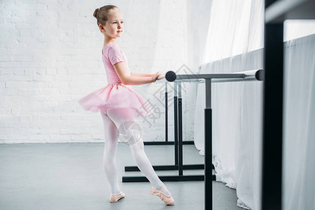 粉红色芭蕾舞裙中可爱的小芭蕾舞女的一面练图片