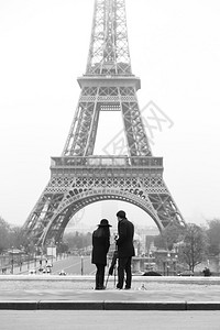 一对年轻夫妇站在战神广场上为埃菲尔铁塔拍照的老式黑白照图片