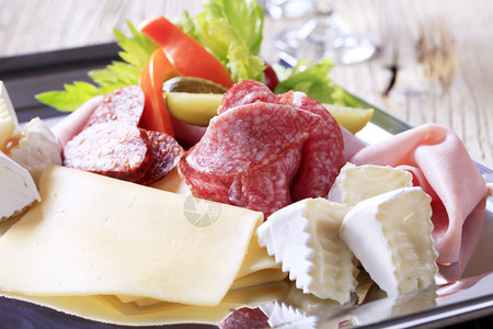 托盘上的各种奶酪和熟食肉图片