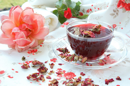一杯玫瑰茶脱水的玫瑰花瓣和背景图片