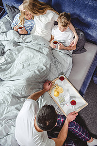 男人给他生病的妻子和躺在床上的孩子送茶水图片