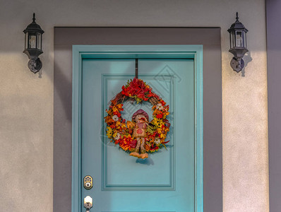 蓝色门两侧的壁灯与花圈犹他州黎明镇一户人家蓝色门两侧的壁灯前门上挂着一个五颜六色背景图片