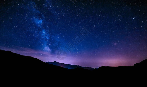 在山上的星夜中蓝色紫的天空背景图片