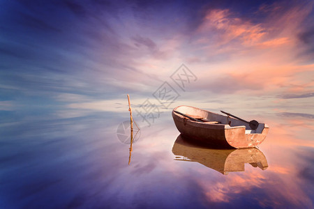 孤独的小船和令人惊叹的海上日落图片