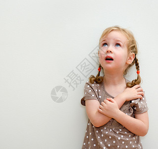 小女孩靠墙仰望的画像图片