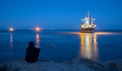 旁观者察拖轮漂浮搁浅船的夜景图片