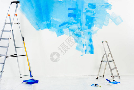 蓝色油漆中的梯子和油漆滚筒刷图片
