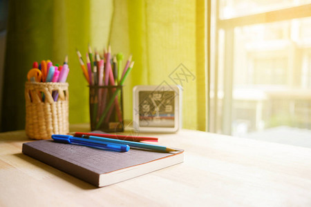 书笔和铅笔放在靠近窗户的桌子上背景图片