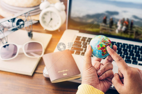 指向世界的旅行者正在计划以笔记本电脑为背景的假期旅行图片