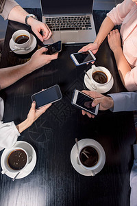商业团队在咖啡馆与智能手机会面时的商业午图片