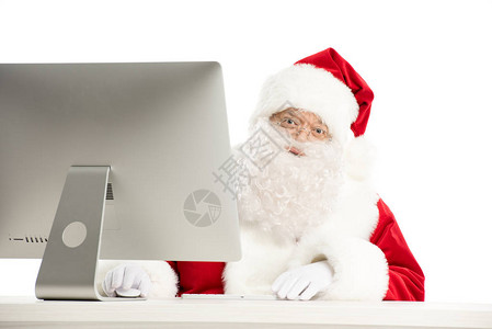 圣诞老人的肖像在用电脑坐在桌子上背景图片