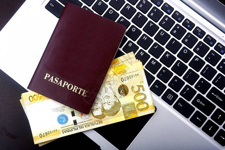 护照及菲律宾比索帐单在笔记本电脑图片