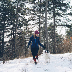 女子跑步者与她的狗在森图片