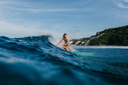 在冲浪板上骑着蓝色海浪图片