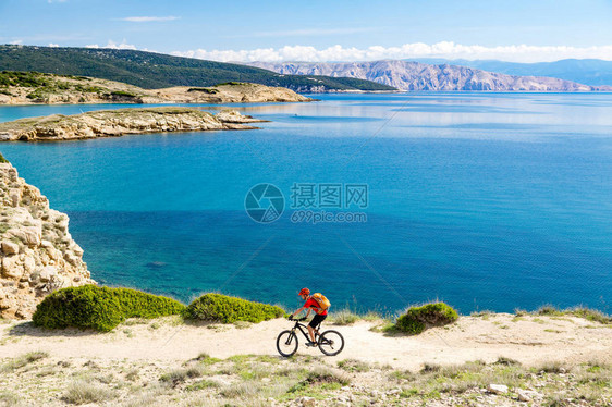 山地自行车骑自行车在夏季或秋季励志山景男子在海边和岩石泥路上的耐力赛小径上骑自行车MTB健身图片