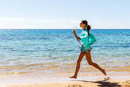 在海滩上户外锻炼时慢跑的女跑步者图片