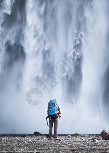 在斯科加瀑布背景上背着包的游客在冰岛旅行游客在冰岛著名的地方旅图片