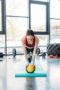 年轻女运动员在健身房健身垫上图片