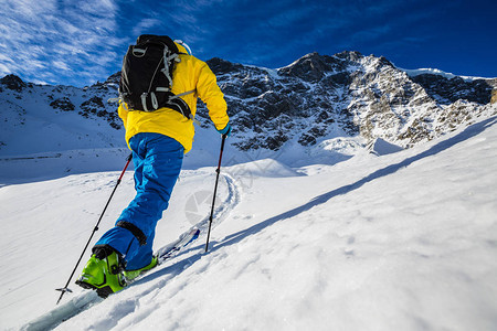 登山者偏远地区滑雪沿着雪脊行走图片