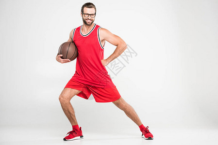穿着红色运动服和反向眼镜的微笑篮球运动员图片