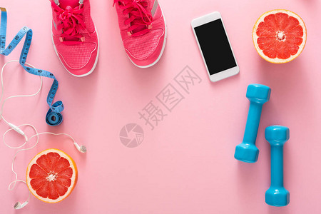 健身背景运动器材复制空间粉色背景中的哑铃葡萄柚运动鞋卷尺和图片