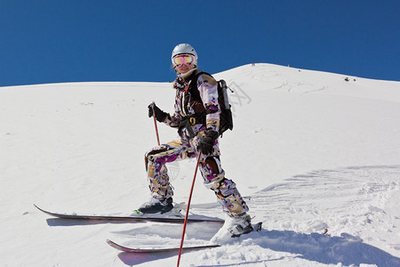 女子滑雪者站在山坡上在阳光明媚的天气下柔图片