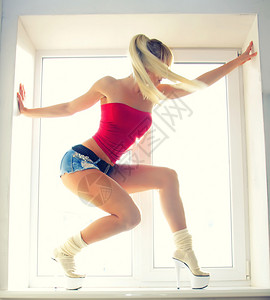 穿着运动感女孩在窗口开图片