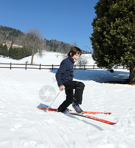 儿童滑雪在山区与越野滑雪板一起坠落图片