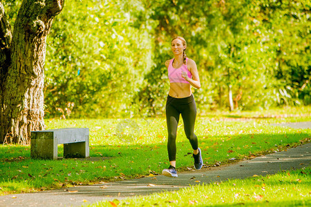 在夏季公园慢跑的女子赛跑者图片