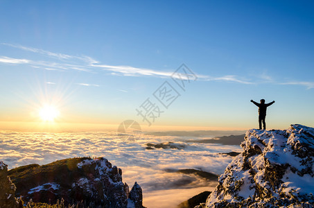 庆祝在日出盛大的山顶上成功登山图片