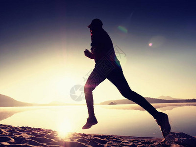 活跃的员赛跑者在日出岸上奔跑的剪影早晨在沙滩上进行健康生活方式锻炼男子背景图片