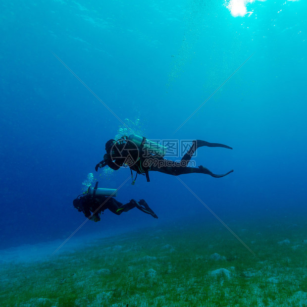 海底附近两名潜水员的剪影图片