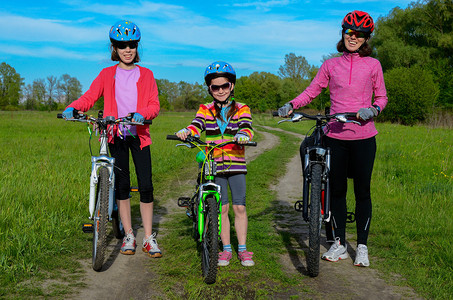快乐的母亲和孩子骑自行车在户外骑自行车活图片
