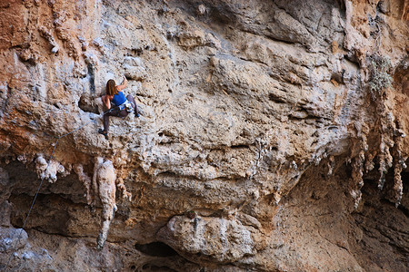 峭壁表面的女攀岩者图片