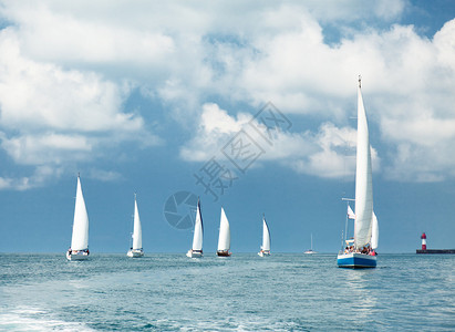 帆船航行蓝多云的天空和白色的风帆图片