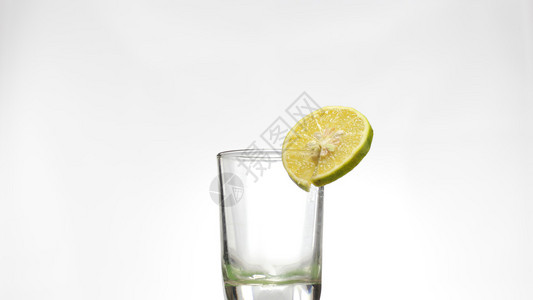 白色背景上加柠檬的空玻璃杯背景图片