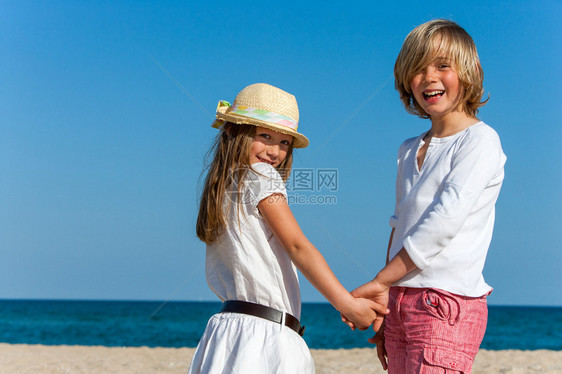在海滩上牵手的可爱男孩图片