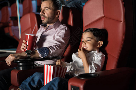 小男孩和爸一起看电影在电影图片