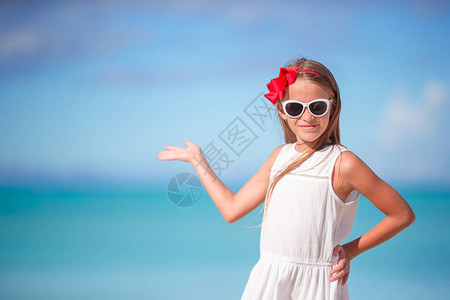 在海滩上穿着衣服的漂亮小女孩玩得开心有趣的女孩图片