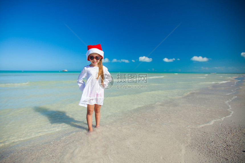 在奇异海滩上戴着红帽子的小女孩图片