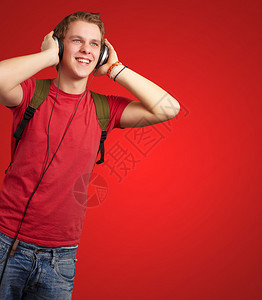 年轻学生用红灯耳机聆听音乐的欢快图片
